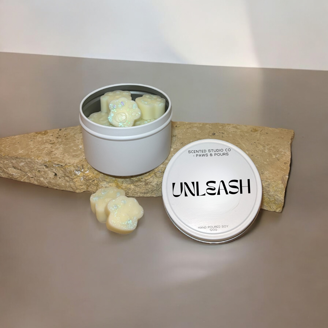 Paw-print soy wax melts packaged in elegant white tins, designed for a clean and eco-friendly aromatic experience