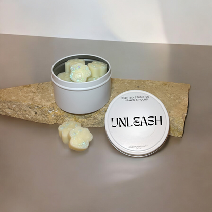 Paw-print soy wax melts packaged in elegant white tins, designed for a clean and eco-friendly aromatic experience