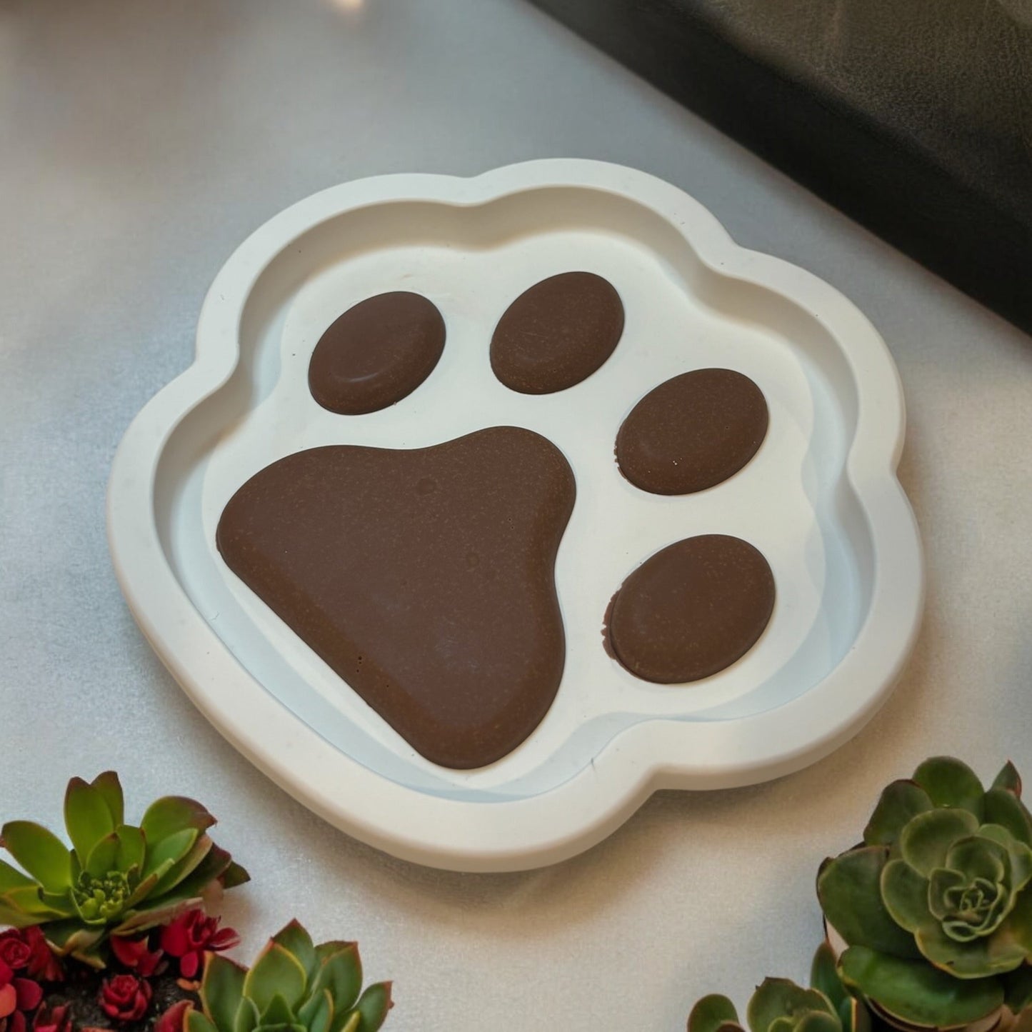 Hand-poured paw-print dish in white and brown tones, crafted from eco-friendly jesmonite, perfect as a decorative or functional piece for pet lovers