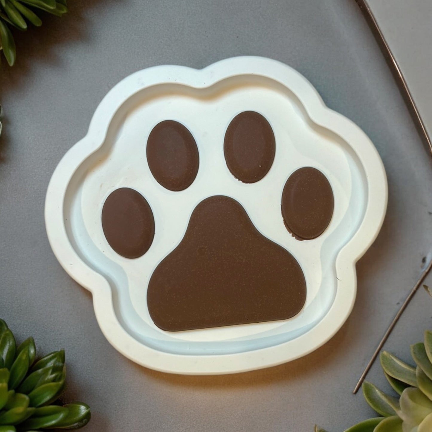 Hand-poured paw-print dish in white and brown tones, crafted from eco-friendly jesmonite, perfect as a decorative or functional piece for pet lovers